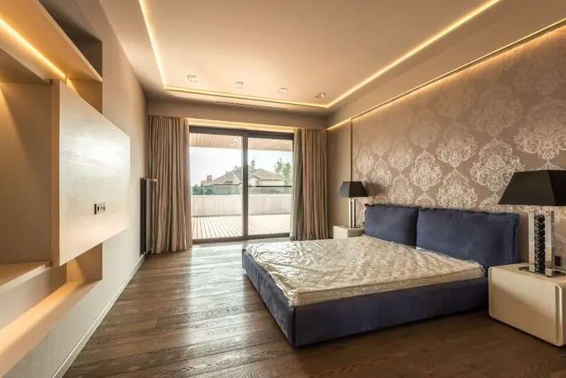 Ambiente com sanca de gesso, iluminação indireta e painel de madeira